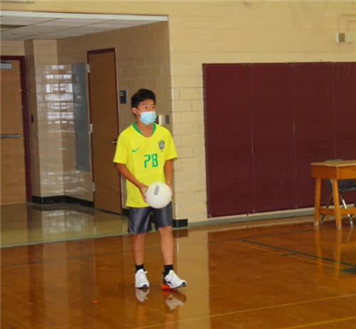 Student serving volleyball 